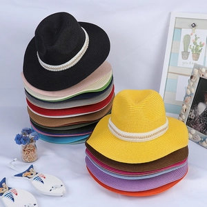 Gros plan de chapeaux Panama en paille colorés avec perles élégantes et chaînes dorées