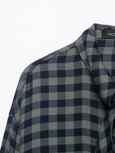 Dettaglio del colletto della camicia a quadri blu e grigi con trama in tessuto twill