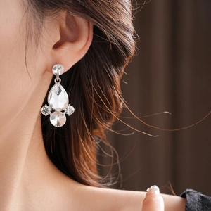 Dettaglio di orecchini a goccia in cristallo argento su modella con strass scintillanti