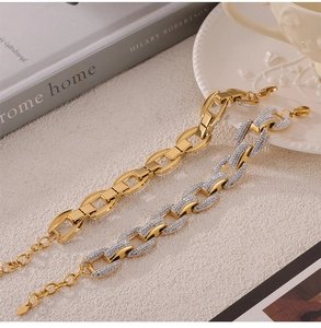 Detailed shot of interlocking gold titanium bracelets with diamonds on a textured surface