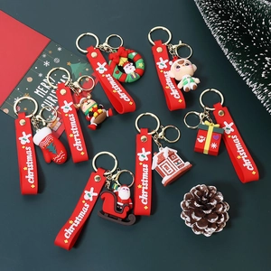 Festive PVC Christmas keychains featuring Santa and reindeer on dark green background