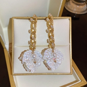 Detail view of French style floral earrings with gold chain, zircons and white pearls