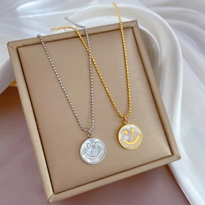 Nahaufnahme von Gold- und Silberketten mit Perlmutt-Anhängern und Smiley-Gesicht