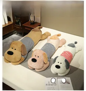 Trois tailles de coussins en peluche chien en marron, beige et blanc sur un lit