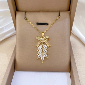 Detailaufnahme der goldenen Schleifen-Halskette mit Diamanten auf eleganter weißer Seide