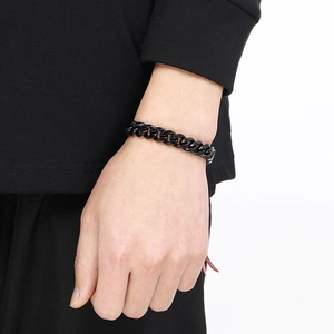 Detailed view of a black stainless steel curb chain bracelet worn on a wrist for men and women