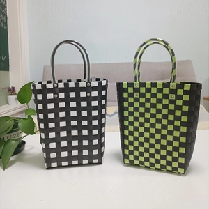 Detail of handmade woven bucket bags featuring black, white, and green plaid patterns