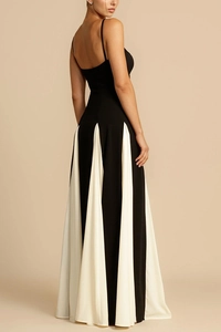 Detail of a chic black and white contrast maxi dress with thin straps and flowy pleated hem