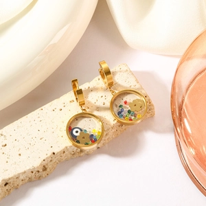 Vintage gold circle earrings with evil eye, floral charms, and colorful beads on stone