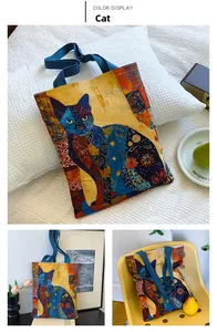 Close-up of artistic cat print canvas tote bag with durable blue handles for daily shopping