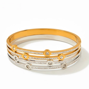 Macro view of gold and silver geometric line bracelets featuring pavé cubic zirconia inlay