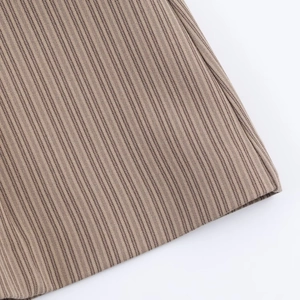 Détail macro du tissu en maille côtelée marron montrant les coutures et la texture