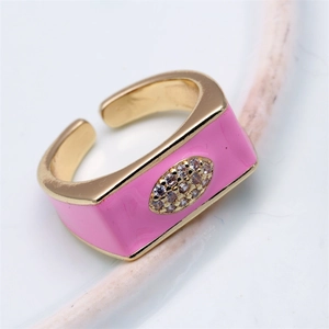Macro shot of gold adjustable ring with pink enamel and sparkling rhinestone evil eye detail