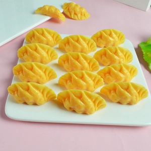 Set realistische gele knoedelmodellen netjes gerangschikt op een wit keramisch bord