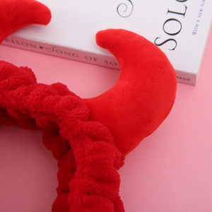 Gros plan sur le serre-tête en peluche rouge avec des cornes de diable douces