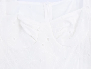 Détail de robe blanche avec broderie anglaise florale et fermeture éclair au dos