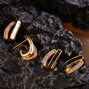 Detail of 18K gold plated U-shaped earrings with enamel inlay and sparkling crystals