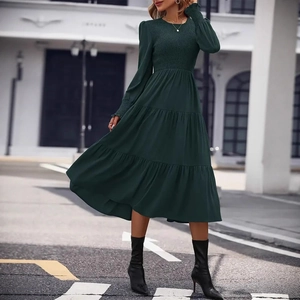 Detail of smocked bodice and tiered hem on a dark green elegant round neck midi dress