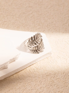 Close-up of a silver titanium steel ring with hollow leaf design on white stone