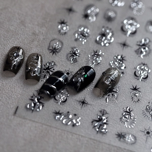 Gothic silver metallic nail stickers with dark moon and star patterns on black nails
