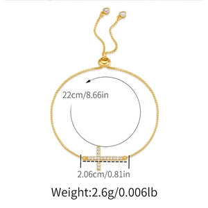 Close-up of gold adjustable bolo bracelet with cross pendant and size specifications