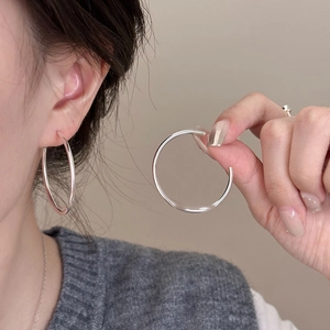 Minimalist silver circular C-shaped earrings on model for a trendy and stylish look
