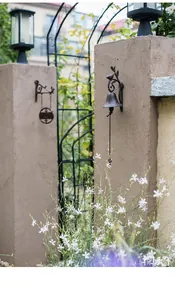 Detailed view of vintage cast iron bird and scroll floral doorbell for garden decor