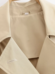 Detail of khaki trench coat collar and refined double-breasted buttonhole stitching