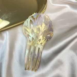 Detail of yellow and purple gradient acetate hair comb with elegant hollow pattern