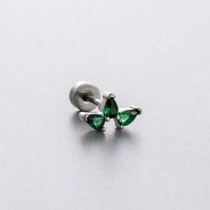 Titanium steel stud with green teardrop crystals in a butterfly shape on grey background