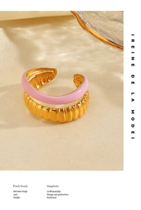 Detail of pink enamel and 18K gold pleated double-layer ring on beige silk fabric