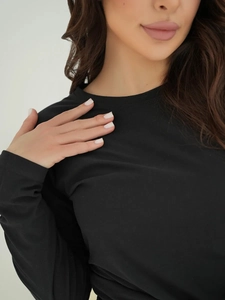 Close-up of neckline stitching and soft fabric texture on black long-sleeve pajamas