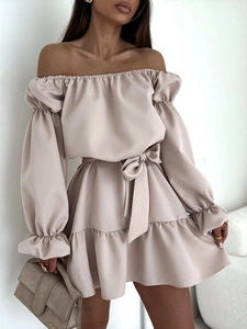 Détail d'une robe en satin champagne à épaules dénudées avec taille nouée et volants