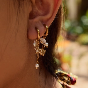 Élégantes boucles d'oreilles dorées avec perles, étoiles en zircon et papillons