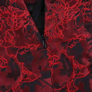 Detailed macro view of red and black floral jacquard fabric with a hidden zipper closure