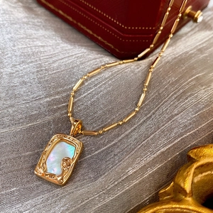 Retro gold-plated square pendant necklace with mother-of-pearl inlay on gray texture
