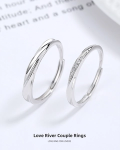 Detail of 925 silver couple rings with twisted design and sparkling stones on book background