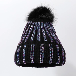 Winter black knitted hat with sparkling AB rhinestones and large fluffy faux fur pompom