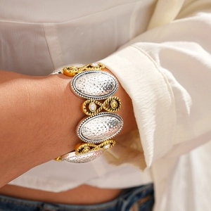 Détail du bracelet bicolore à maillons ovales martelés avec de petits accents en cristal