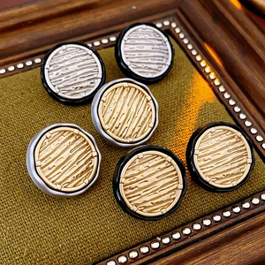 Macro view of vintage style round metal buttons with wood grain texture in golden and silver