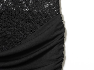 Dettaglio di pizzo nero elegante sul tessuto plissettato di un abito all'americana
