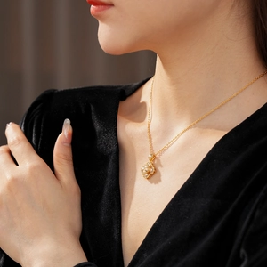 Vue détaillée d'un collier fleur plaqué or avec perles porté par un mannequin