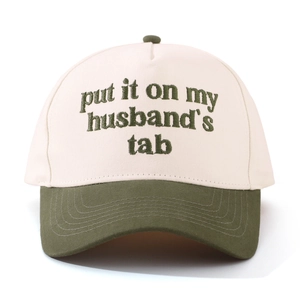 Close-up of contrast embroidery on cotton trucker cap with cream crown and green brim