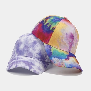 Detail view of colorful tie-dye and abstract oil painting patterns on baseball caps