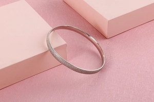 Detail of silver titanium steel bangle featuring a frosted glitter finish and inner mirror polish