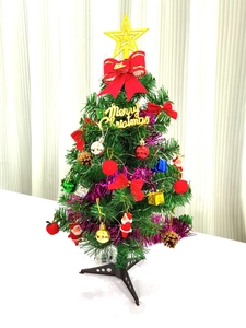 Detailed close-up of a 60cm mini Christmas tree with festive red bows and gold ornaments