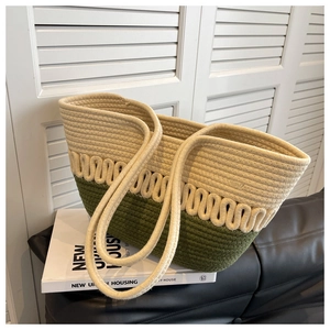 Detail of green and beige woven tote bag with cotton rope handles on a leather sofa