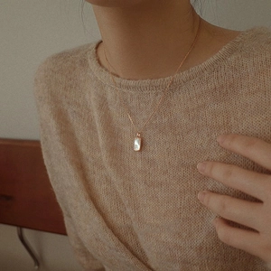 Detail of a gold S925 silver shell pendant necklace worn on a woman neck for styling
