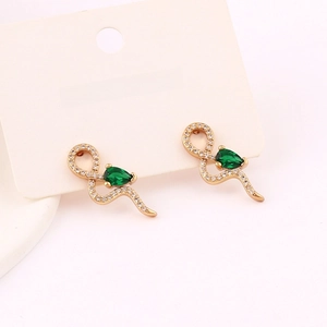 Detail of snake earrings featuring green pear-cut gemstones and white diamond accents