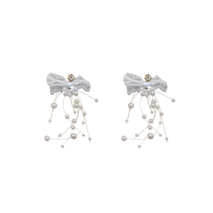 Boucles d'oreilles nœud en dentelle avec glands de perles et strass sur fond blanc